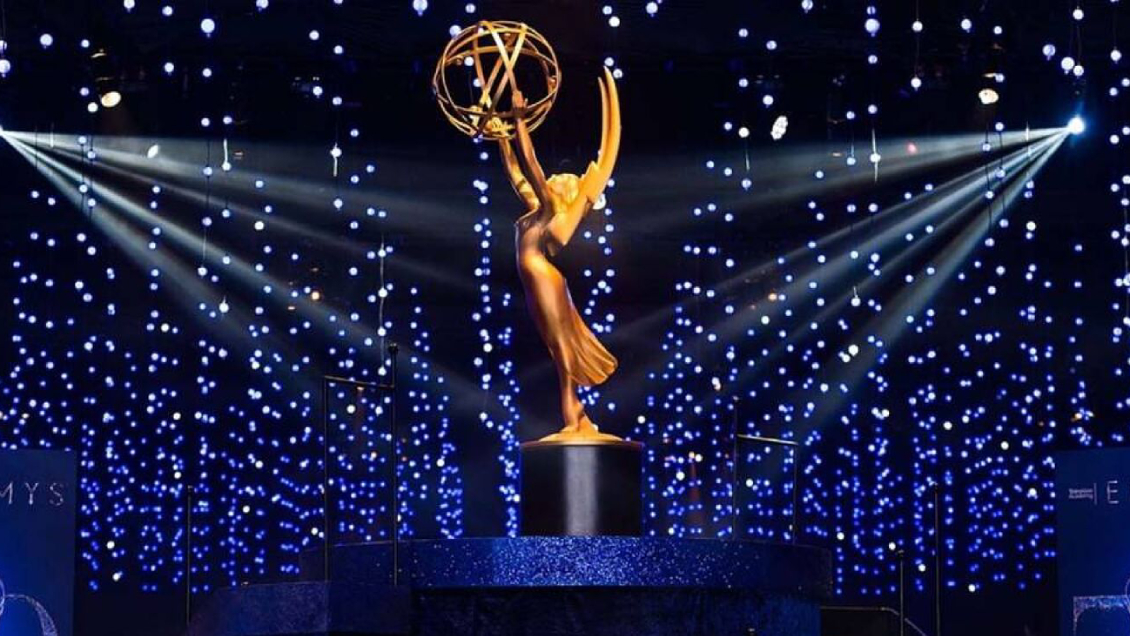 Un Premio Emmy color dorado rodeado de luces.