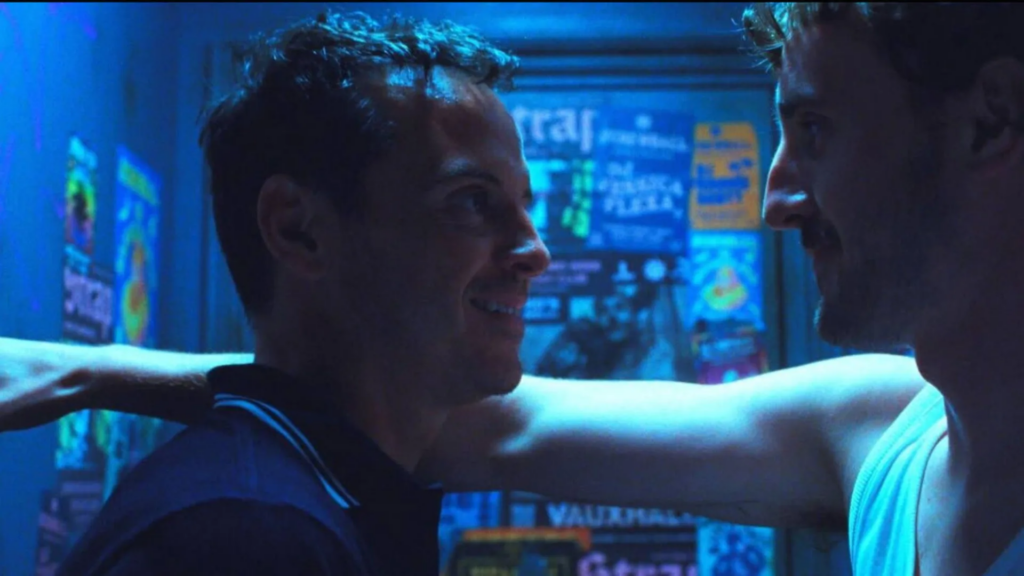 Adam (Andrew Scott) le sonríe a otro hombre en el baño de un club en una escena de All of us strangers (2023).